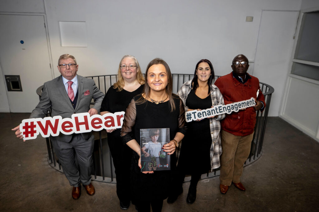 Image of Supporting communities and tenant action group members holding #wehear cutouts and #tenantengagment cutouts.