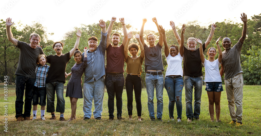 Stock photo of a group of diverse people outside waving and smiling at the camera